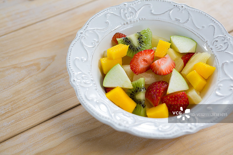 木桌上盘中各种切碎的水果特写图片素材