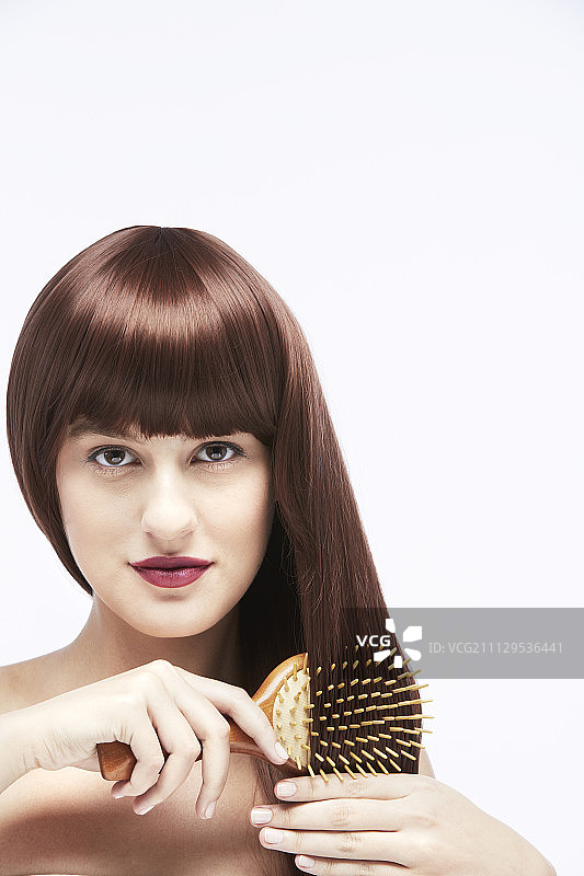 在白色背景下梳头发的女人图片素材
