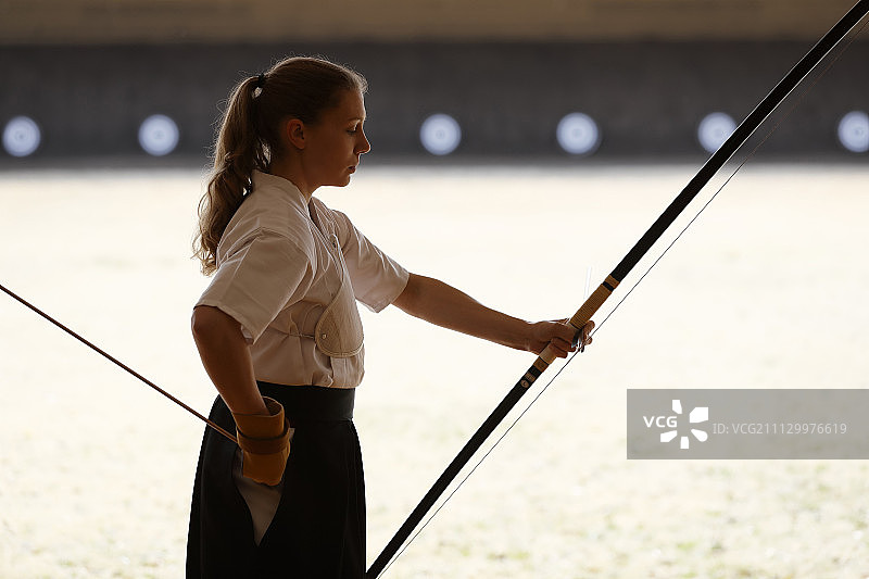 练习传统弓道的白人女性图片素材