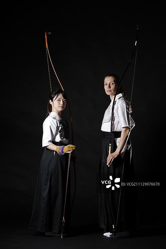 黑色背景上的各民族传统弓道日本射箭运动员图片素材