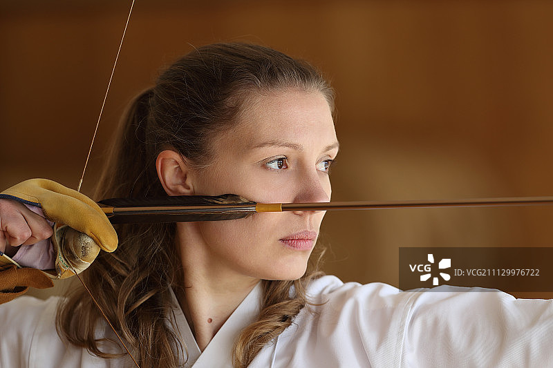 练习传统弓道的白人女性图片素材