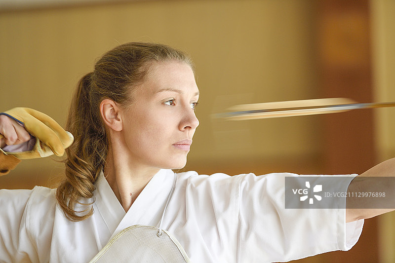 练习传统弓道的白人女性图片素材