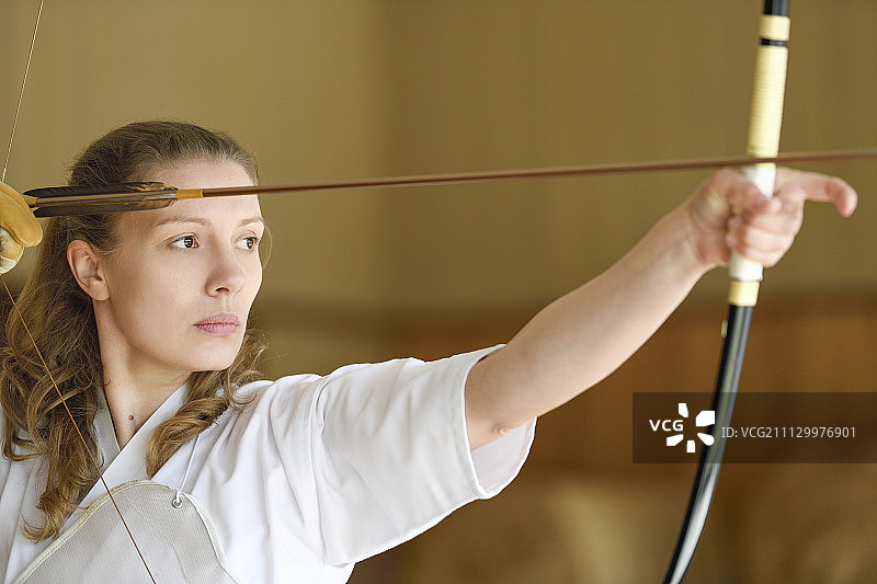 练习传统弓道的白人女性图片素材