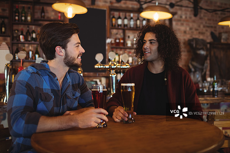 快乐的朋友们在酒吧喝啤酒图片素材