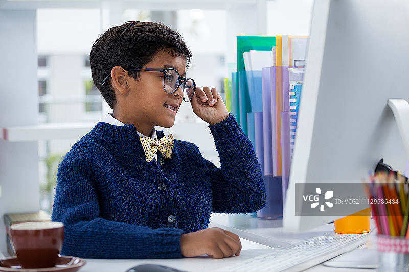 在办公室办公桌前工作的微笑男商人图片素材