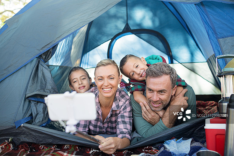 在露营地帐篷里自拍的微笑家庭图片素材