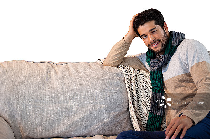 在白色背景的沙发上放松的微笑男士肖像图片素材