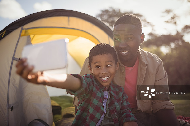 公园里用手机自拍的快乐父子图片素材
