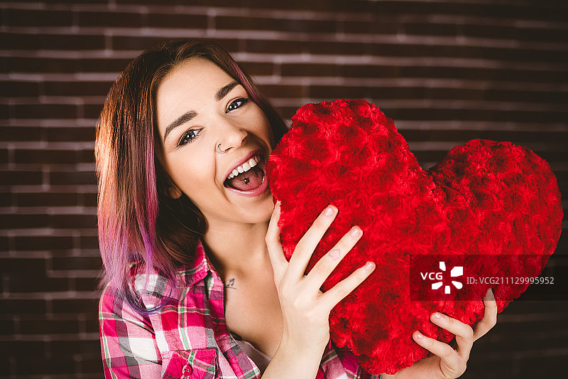 笑容满面的女人手持心形的肖像图片素材