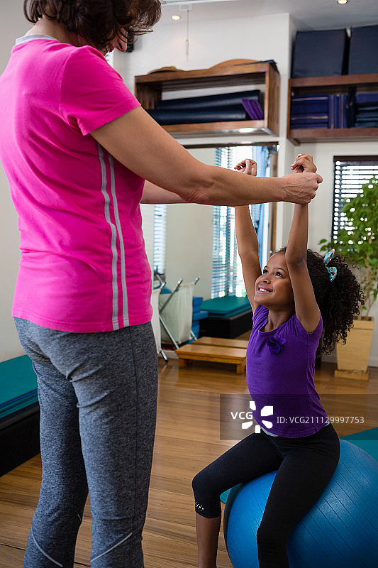 女理疗师在诊所帮助女病人进行哑铃运动图片素材