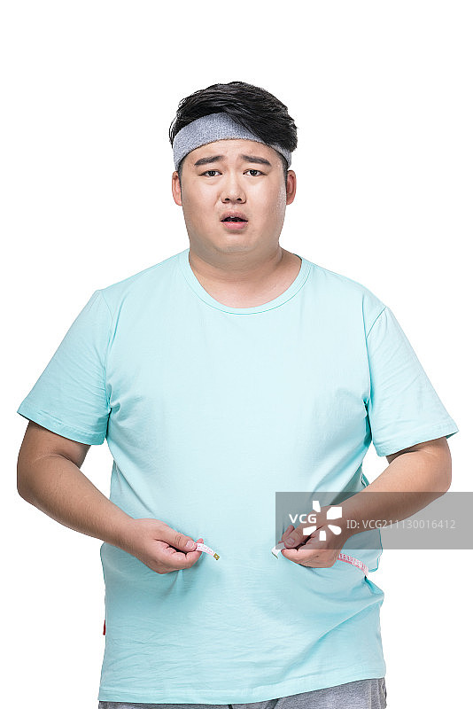 肥胖的年轻男子量腰围图片素材