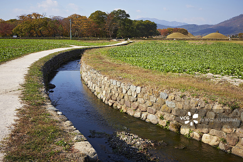 草地、溪流和韩国传统坟墓的景色图片素材