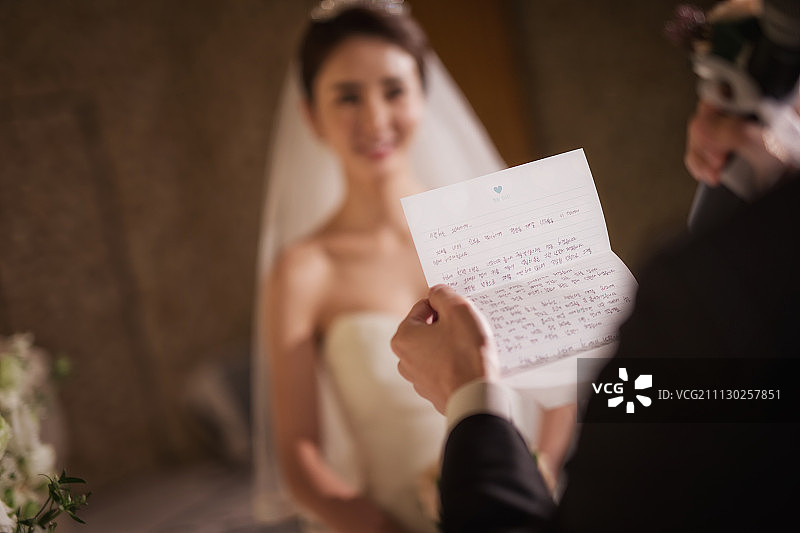 在婚礼大厅里读信的燕尾服男人照片图片素材