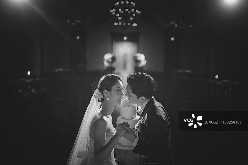 身穿婚纱礼服的情侣在婚礼殿堂亲吻摄影图片素材