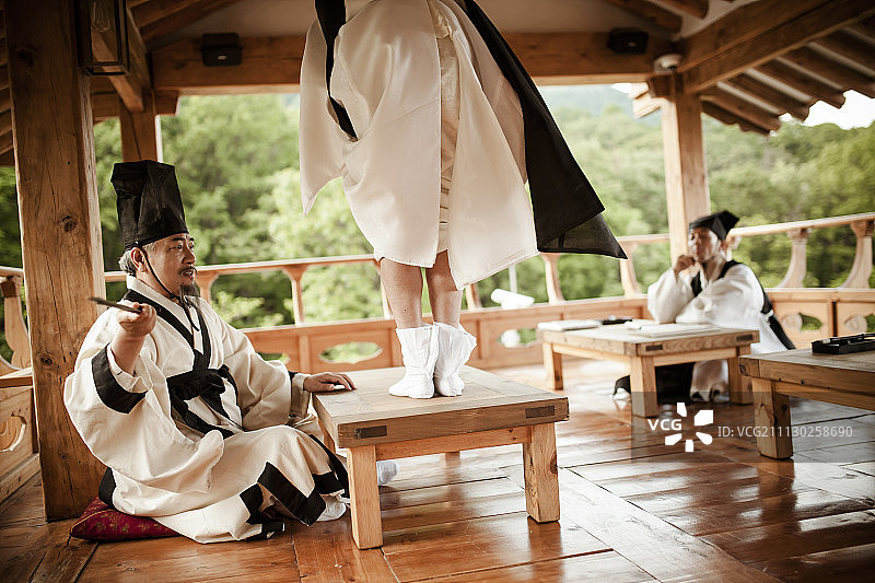 老师管教穿着传统韩国服装的学生图片素材