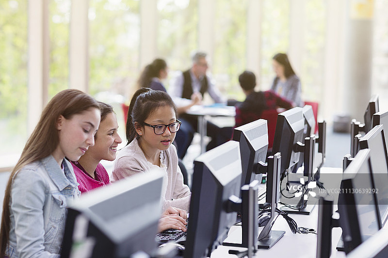 在图书馆用电脑学习的女学生图片素材