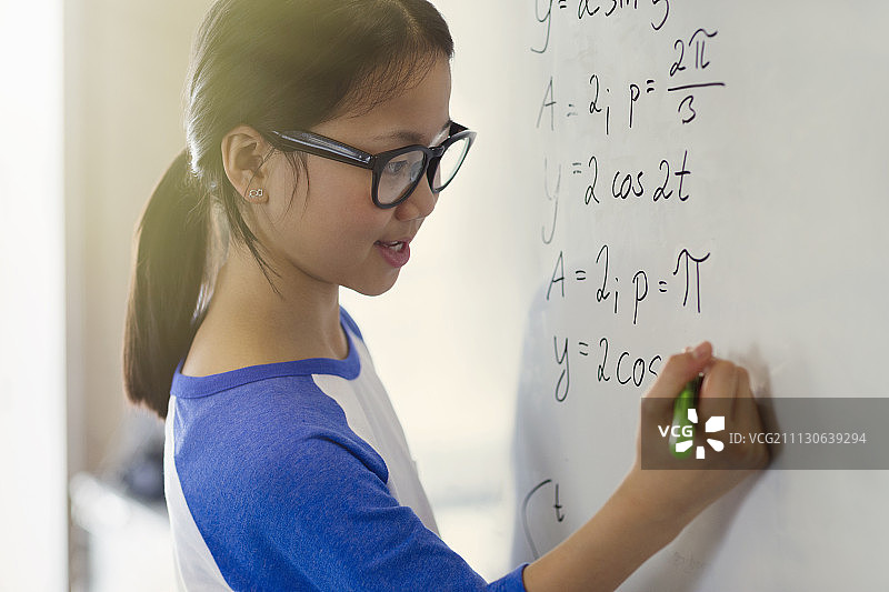 自信的女学生在教室白板上解物理方程式的微笑肖像图片素材