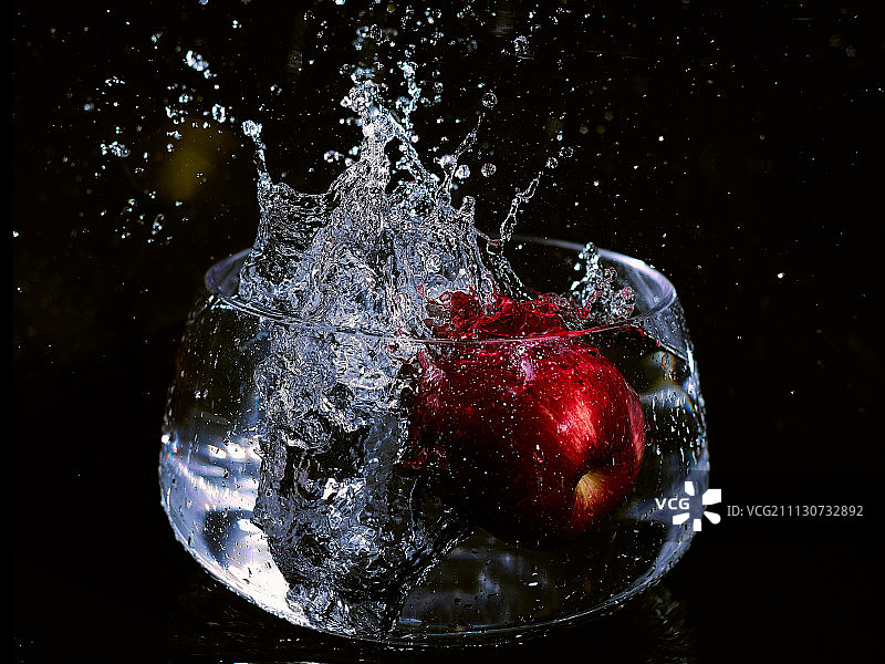 高速状态下的苹果落入水中图片素材