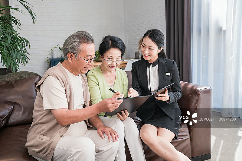 年轻女子向一对老夫妻介绍产品图片素材