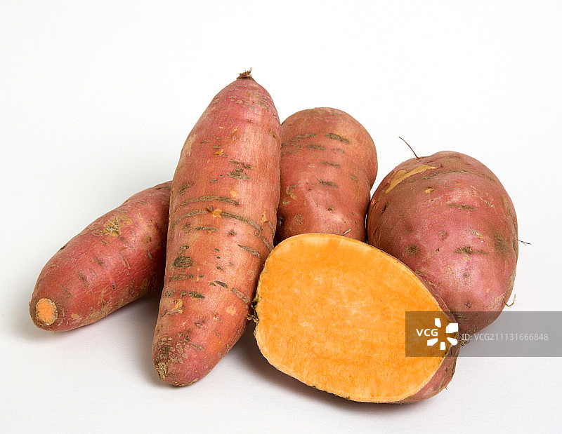 白底的一组甘薯，切成两半以显示橙色内部图片素材