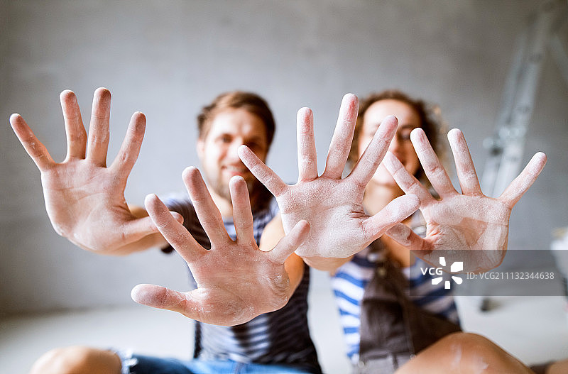 年轻夫妇在新家粉刷墙壁图片素材