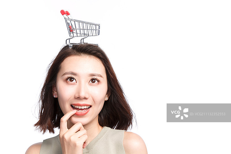 快乐的年轻女孩头顶购物车图片素材