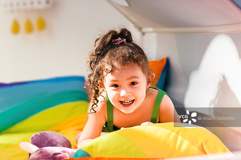 可爱的小女孩在床上玩耍图片素材