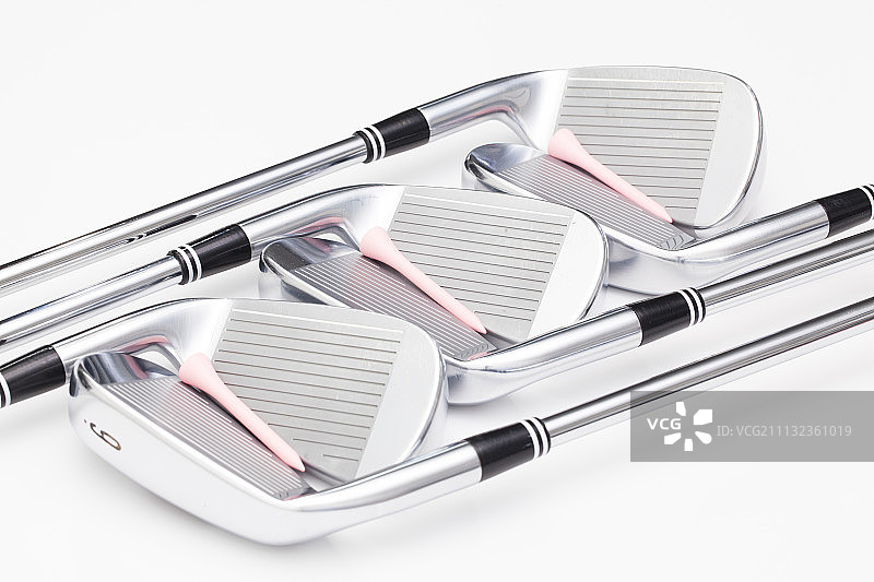 白色桌子上的钛金属高尔夫球杆图片素材