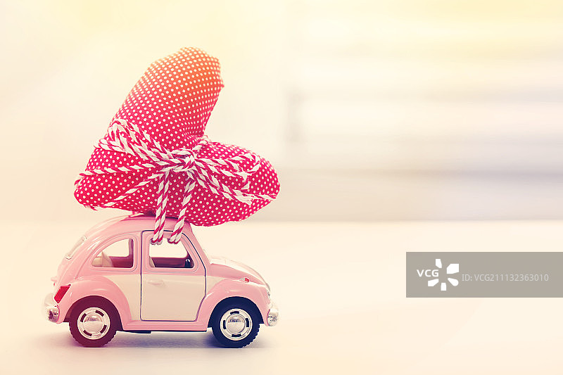 载着红色心形靠垫的微型车图片素材