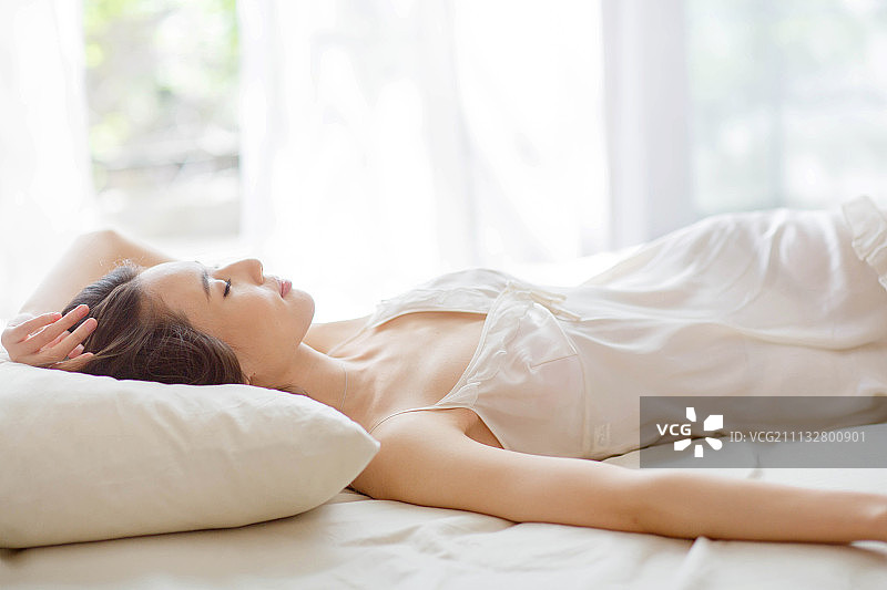 青年女人躺在床上睡觉图片素材
