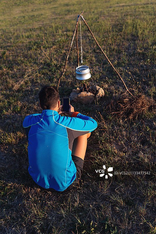 男人在野外露营并使用智能手机图片素材