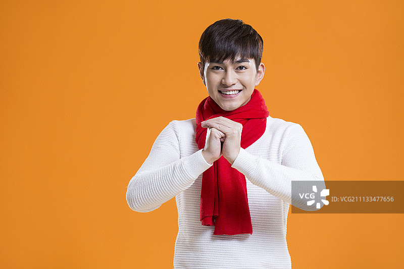 快乐的年轻男子作揖拜年图片素材