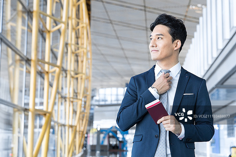 年轻商务男士拿着护照和机票图片素材