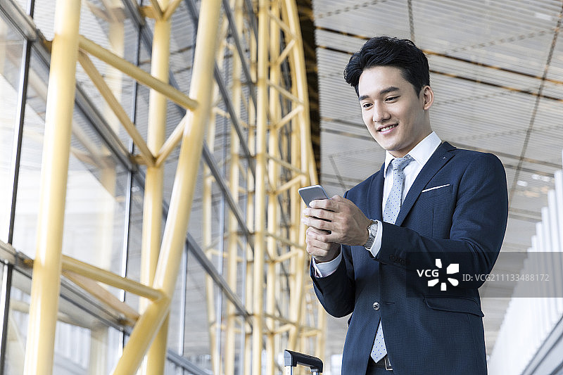 年轻商务男士在机场使用手机图片素材