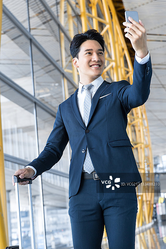 年轻商务男士用手机自拍在机场图片素材