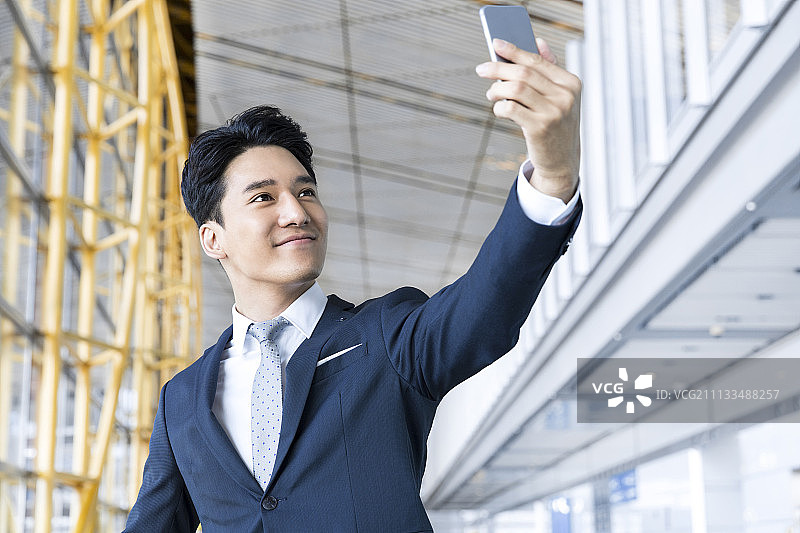 年轻商务男士用手机自拍在机场图片素材