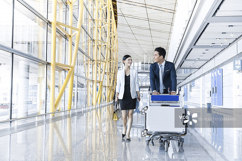 年轻商务人士在机场推行李车图片素材