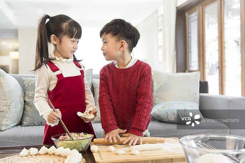 快乐的男孩女孩庆新年包饺子图片素材