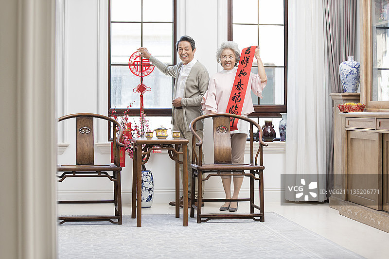 快乐的老年夫妇在家布置新年装饰图片素材