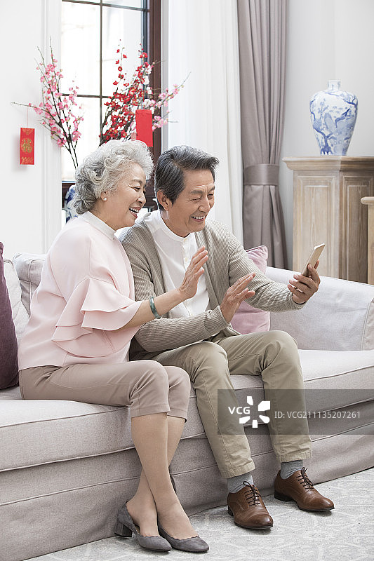 快乐老年夫妇新年用手机视频聊天图片素材
