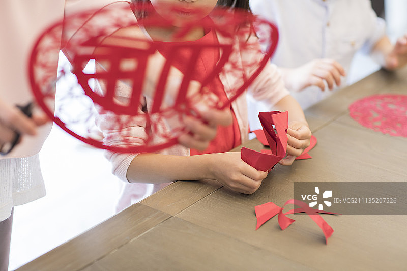 快乐的奶奶教孙子们剪新年窗花图片素材