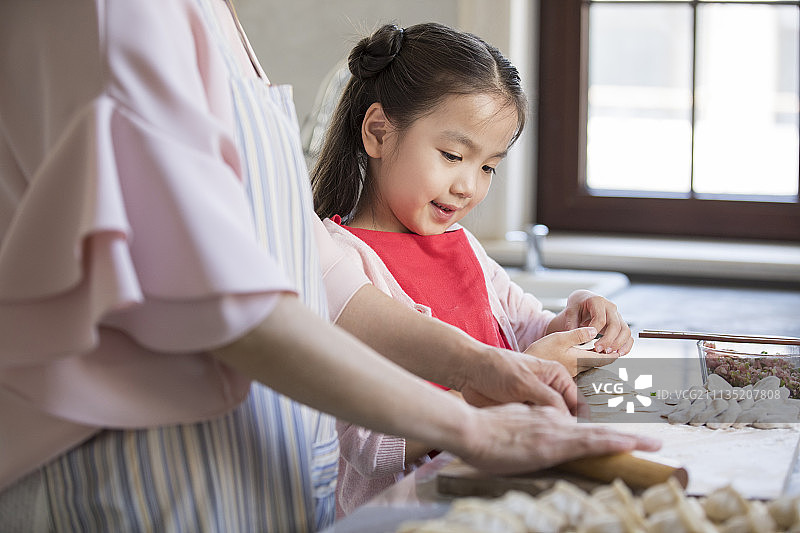 快乐的奶奶和孙女在厨房包饺子图片素材