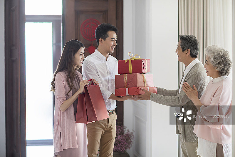 年轻夫妇带着礼物给父母拜年图片素材