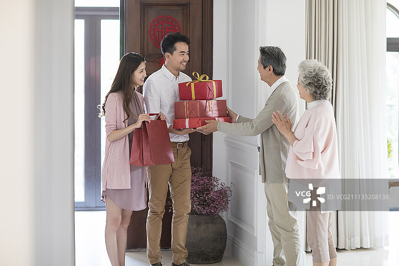年轻夫妇带着礼物给父母拜年图片素材