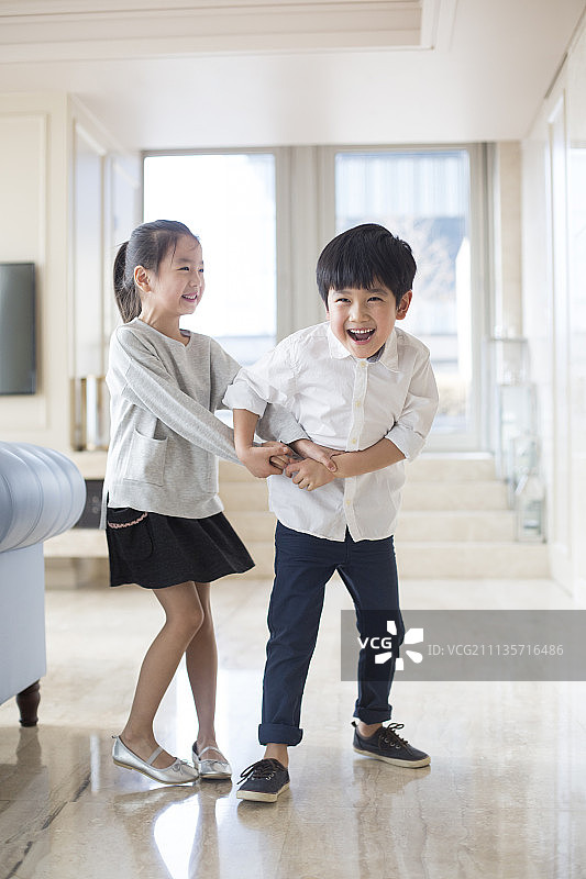 快乐的兄妹俩在客厅玩耍图片素材