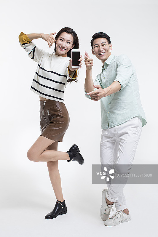 快乐的年轻情侣展示手机图片素材