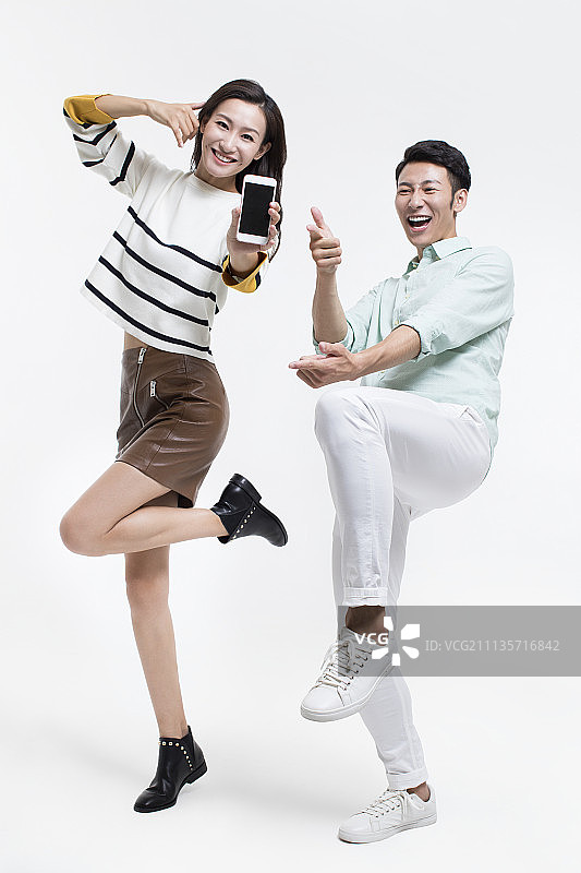 快乐的年轻情侣展示手机图片素材