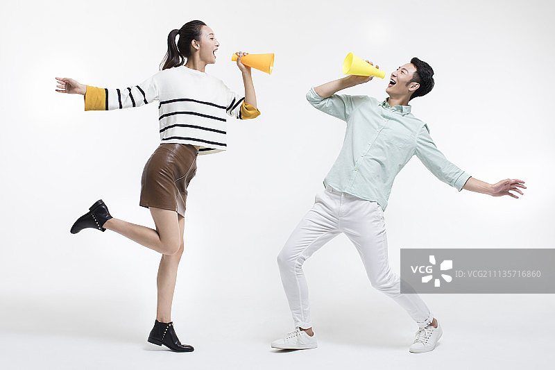 年轻情侣用扩音器传递好消息图片素材