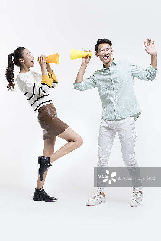 年轻情侣用扩音器传递好消息图片素材