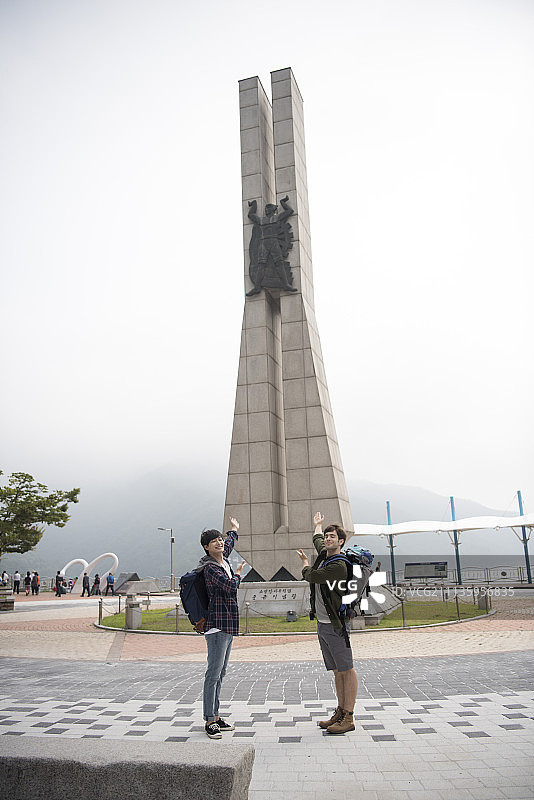 两名背包客站在春川市的地标前图片素材